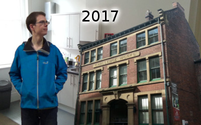 With my new flat as a background, I stand there with my ever-blue jacket next to a picture of the housing complex "Challenge Works".